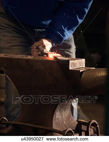 Stock Photo - Farrier forging horseshoe on anvil. Fotosearch