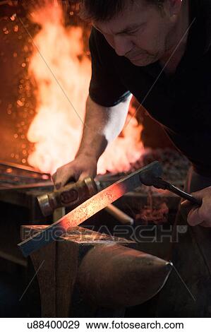 Stock Photo - Farrier forging horseshoe on anvil. Fotosearch