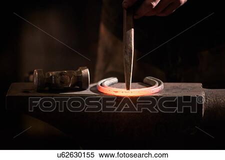 Stock Photography - Farrier forging horseshoe on anvil. Fotosearch