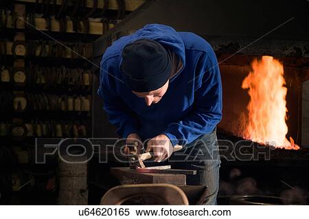 Stock Photography - Farrier forging horseshoe on anvil. Fotosearch