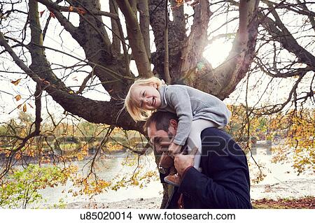 Picture - Father carrying daughter on shoulders. Fotosearch