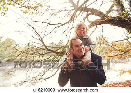 Stock Photo - Father carrying daughter on shoulders. Fotosearch