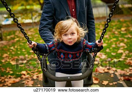 Father pushing daughter on playground swing View Large Photo Image Stock Photo - Father pushing daughter on playground swing. Fotosearch