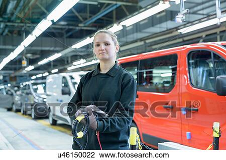 Stock Image - Female apprentice engineer on production line in car factory, portrait. Fotosearch