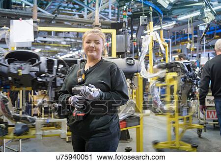 Stock Image - Female apprentice engineer on production line in car factory, portrait. Fotosearch