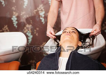 Female customer having hair washed in salon sink View Large Photo Image Picture - Female customer having hair washed in salon sink. Fotosearch