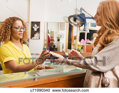 Female customer paying with credit card reader in hair salon View Large Photo Image Stock Image - Female customer paying with credit card reader in hair salon. Fotosearch
