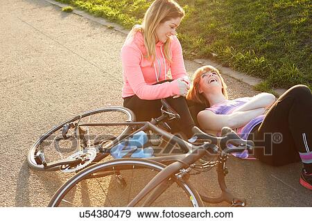 Female cyclists with racing cycle taking a break in park View Large Photo Image Stock Photo - Female cyclists with racing cycle taking a break in park. Fotosearch