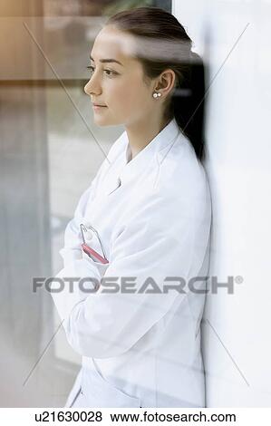 Female doctor leaning against wall, pensive expression View Large Photo Image Stock Photo - Female doctor leaning against wall, pensive expression. Fotosearch