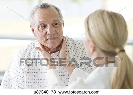 Stock Photo - Female doctor touching senior man's neck. Fotosearch