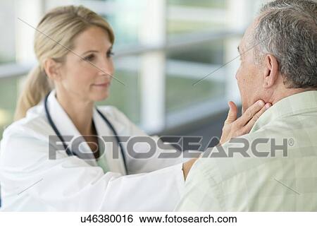 Stock Photograph - Female doctor touching senior man's neck. Fotosearch