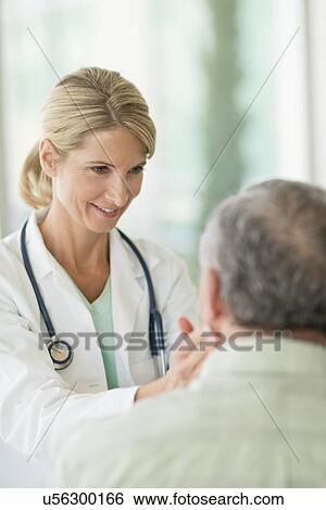 Stock Photograph - Female doctor touching senior man's neck. Fotosearch