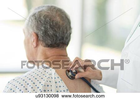Female doctor using stethoscope on male patient View Large Photo Image Stock Photo - Female doctor using stethoscope on male patient. Fotosearch