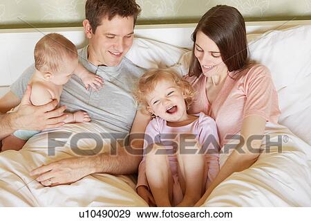 Female toddler and baby sister in bed with parents View Large Photo Image Stock Photo - Female toddler and baby sister in bed with parents. Fotosearch