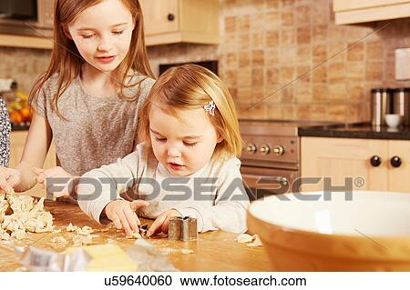 Female toddler and big sister making star shape pastry at kitchen table View Large Photo Image Stock Image - Female toddler and big sister making star shape pastry at kitchen table. Fotosearch
