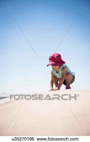 Female toddler crouching on top of sand dune, Little Sahara, Utah, USA View Large Photo Image Stock Photograph - Female toddler crouching on top of sand dune, Little Sahara, Utah, USA. Fotosearch