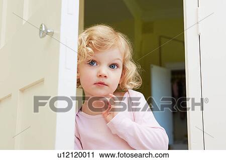 Female toddler peering from door View Large Photo Image Stock Image - Female toddler peering from door. Fotosearch