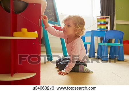 Female toddler playing on playroom floor View Large Photo Image Stock Image - Female toddler playing on playroom floor. Fotosearch