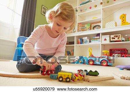 Female toddler playing with toy train on playroom floor View Large Photo Image Stock Photo - Female toddler playing with toy train on playroom floor. Fotosearch