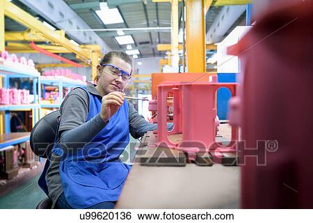 Stock Photograph - Female worker finishing wax component in precision casting factory. Fotosearch