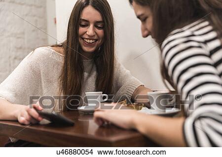 Picture - Friends at table in coffee shop. Fotosearch