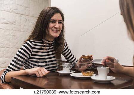Friends at table in coffee shop View Large Photo Image Stock Photo - Friends at table in coffee shop. Fotosearch