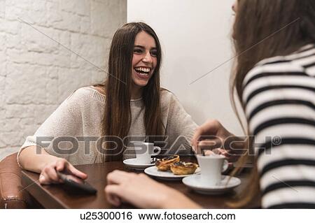 Friends at table in coffee shop View Large Photo Image Stock Photograph - Friends at table in coffee shop. Fotosearch