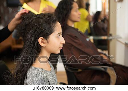 Stock Photo - Girl and mother having their hair styled in hair salon. Fotosearch