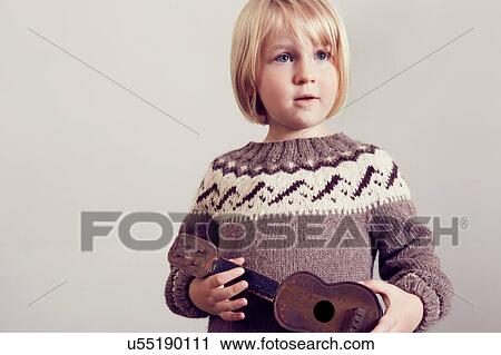 Girl holding old wooden toy guitar View Large Photo Image Stock Image - Girl holding old wooden toy guitar. Fotosearch