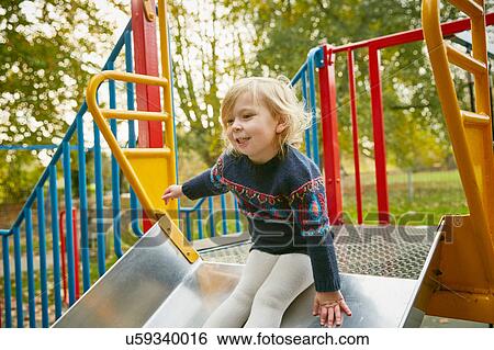 Girl on playground slide View Large Photo Image Stock Photograph - Girl on playground slide. Fotosearch