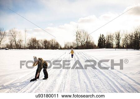 Girl picking up mitten on snow-covered path, Lakefield, Ontario, Canada View Large Photo Image Stock Image - Girl picking up mitten on snow-covered path, Lakefield, Ontario, Canada. Fotosearch