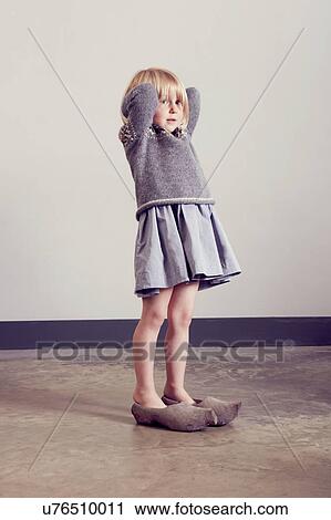 Girl standing in vintage wooden clogs with hands behind head View Large Photo Image Stock Image - Girl standing in vintage wooden clogs with hands behind head. Fotosearch