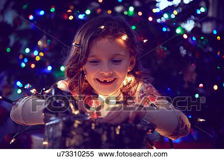 Girl surrounded by lights wrapping christmas presents at christmas View Large Photo Image Stock Photography - Girl surrounded by lights wrapping christmas presents at christmas. Fotosearch