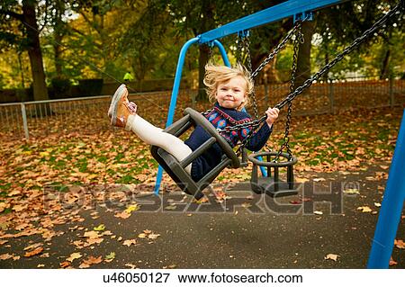 Stock Photo - Girl swinging on playground swing. Fotosearch
