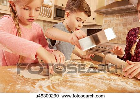 Girls and boy baking star shape pastry at kitchen table View Large Photo Image Stock Image - Girls and boy baking star shape pastry at kitchen table. Fotosearch
