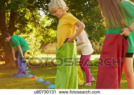 Girls and boys preparing for sack race on start line in park View Large Photo Image Stock Image - Girls and boys preparing for sack race on start line in park. Fotosearch