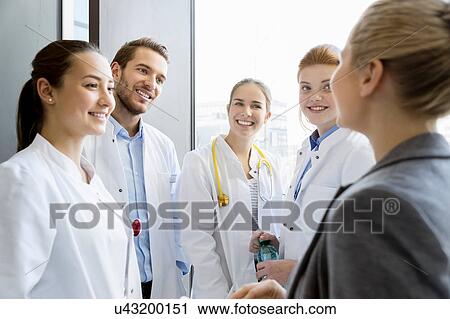 Group of doctors having discussion with consultant View Large Photo Image Stock Image - Group of doctors having discussion with consultant. Fotosearch
