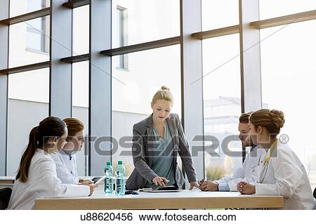 Group of doctors in meeting with consultant View Large Photo Image Stock Photograph - Group of doctors in meeting with consultant. Fotosearch