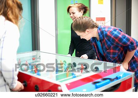 Group of female friends playing table football View Large Photo Image Stock Image - Group of female friends playing table football. Fotosearch