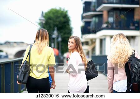 Stock Photograph - Group of young women walking outdoors, rear view. Fotosearch
