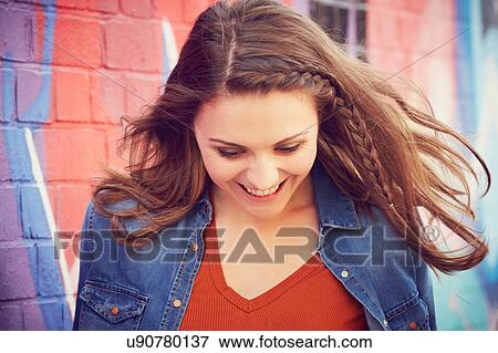 Stock Photo - Happy woman with head down, London, UK. Fotosearch