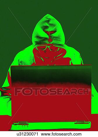 Stock Image - Hooded figure hacking laptop computer. Fotosearch