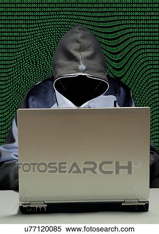 Stock Photography - Hooded figure hacking laptop computer. Fotosearch