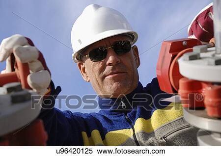 Industrial worker turning wheel on pipeline View Large Photo Image Stock Photography - Industrial worker turning wheel on pipeline. Fotosearch
