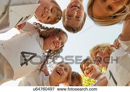 Low angle view of boy and girl sport team huddled in circle View Large Photo Image Stock Photo - Low angle view of boy and girl sport team huddled in circle. Fotosearch