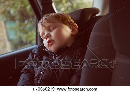 Stock Photo - Male toddler asleep in car backseat. Fotosearch