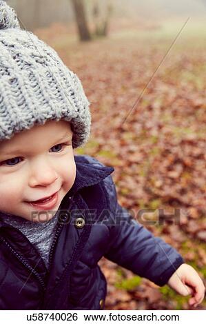 Stock Photograph - Male toddler in knitted hat in forest. Fotosearch