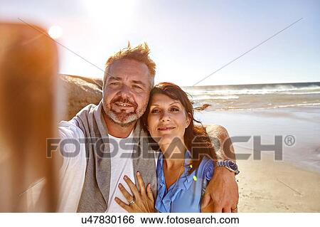 Mature couple taking selfie on beach, Cape Town, South Africa View Large Photo Image Stock Photograph - Mature couple taking selfie on beach, Cape Town, South Africa. Fotosearch
