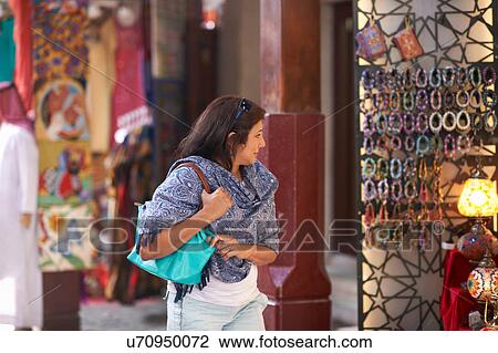 Mature female tourist strolling and looking at market stall, Sharjah, United Arab Emirates View Large Photo Image Stock Image - Mature female tourist strolling and looking at market stall, Sharjah, United Arab Emirates. Fotosearch