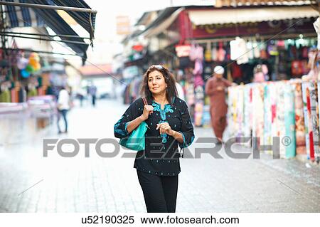 Mature female tourist strolling in market at Sharjah, United Arab Emirates View Large Photo Image Stock Photography - Mature female tourist strolling in market at Sharjah, United Arab Emirates. Fotosearch